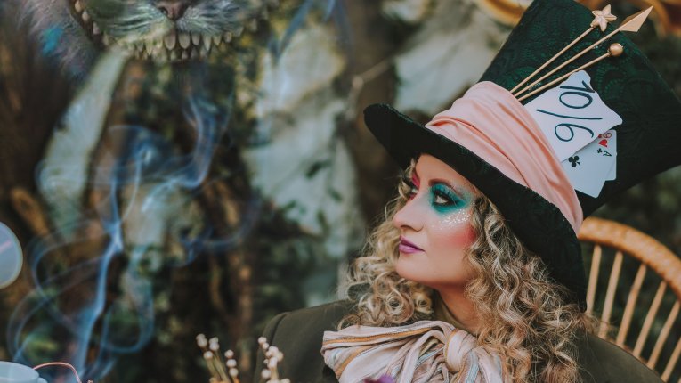 Zdjęcie przedstawiające Kapelusznicę i Kota przy zastawionym stoliczku. Stylistyka Alicji w krainie czarów.