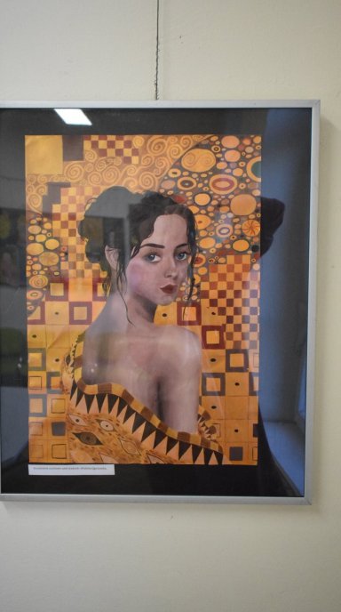 Portret młodej kobiety enface "otulonej" teksturą pełną klimtowskich ornamentów i tekstur w ciepłych kolorach, spośród których dominuje złoto.