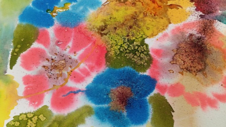 Zbliżenie na malunek akwarelowy przedstawiający kolorowe kwiaty o rozmytych krawędziach w intensywnych kolorach różu, błękitu i żółci.