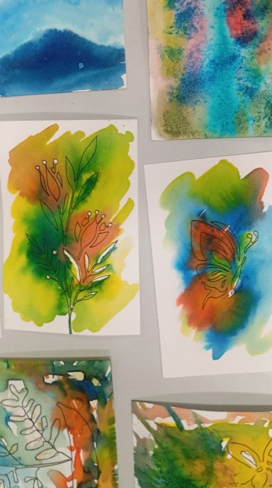 Kolaż prac akwarelowych przedstawiających kolorowe rośliny, kwiaty i motyla, wykonanych techniką łączenia plam barwnych z delikatnym rysunkiem.