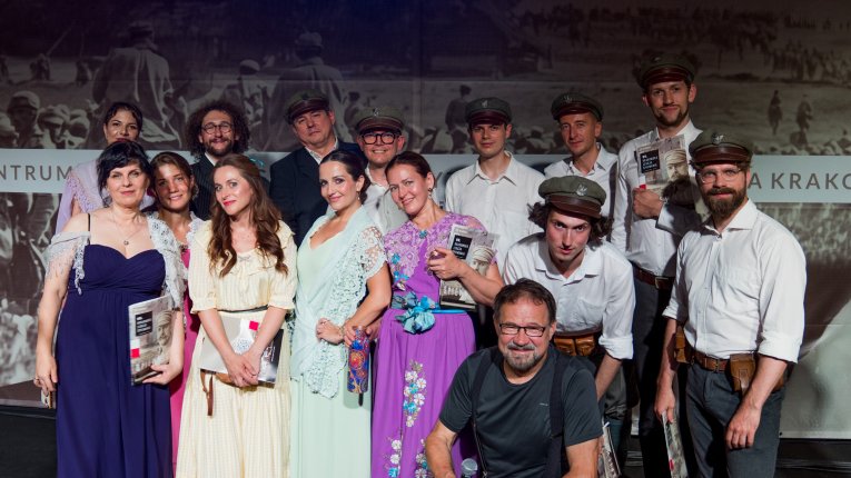 Artyści teatru Loch Camelot w strojach legionistów i dam śpiewaja pieśni patriotyczne