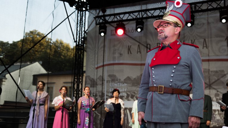 Artyści teatru Loch Camelot w strojach legionistów i dam śpiewaja pieśni patriotyczne