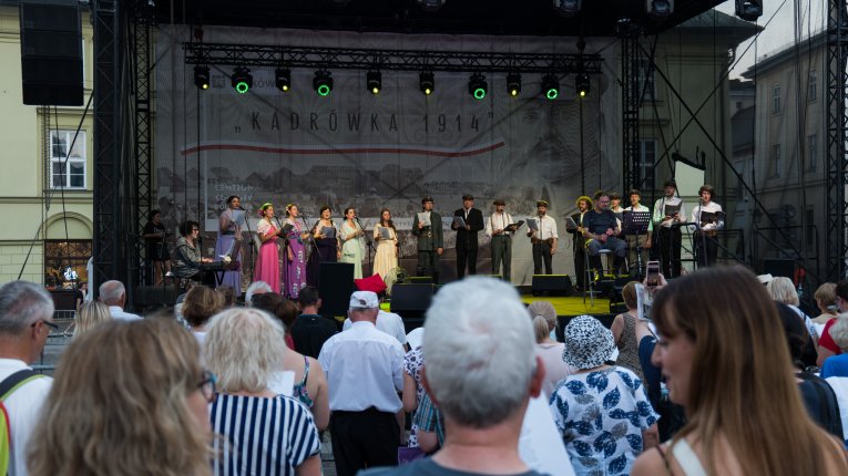 Artyści teatru Loch Camelot w strojach legionistów i dam śpiewaja pieśni patriotyczne