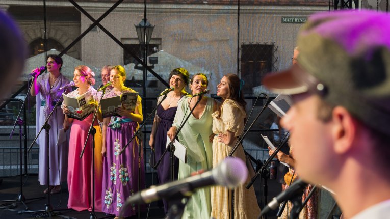 Artyści teatru Loch Camelot w strojach legionistów i dam śpiewaja pieśni patriotyczne