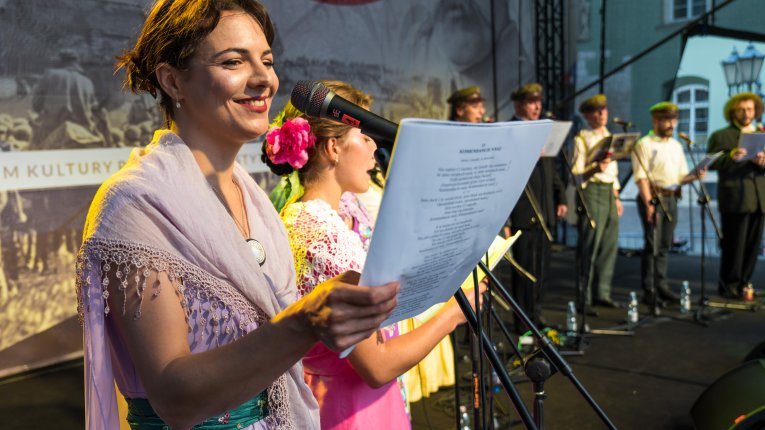 Artyści teatru Loch Camelot w strojach legionistów i dam śpiewaja pieśni patriotyczne