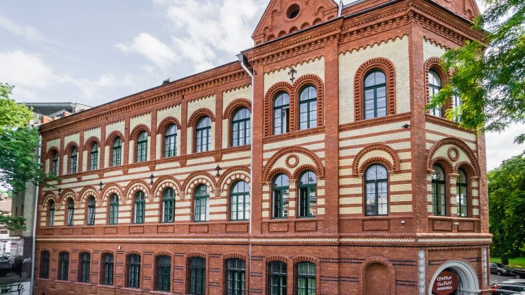 Budynek Centrum Kultury Podgórza – zabytkowy, neogotycki gmach z czerwonej i jasnej cegły, z dużymi łukowymi oknami. Budynek otoczony jest zielenią, a przed wejściem widoczne jest oznaczenie „Centrum Kultury Podgórza
